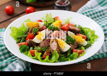 Warmer Salat mit Geflügelleber, grüne Bohnen, Eiern, Tomaten und Balsamico-dressing Stockfoto