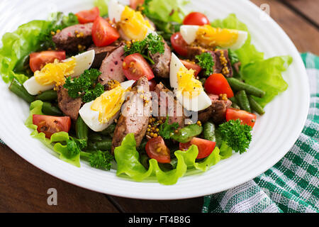 Warmer Salat mit Geflügelleber, grüne Bohnen, Eiern, Tomaten und Balsamico-dressing Stockfoto