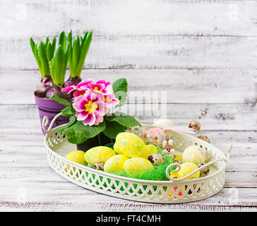 Ostereier und Blumen auf einem hölzernen Hintergrund Stockfoto