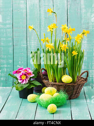 Ostereier und Blumen auf einem hölzernen Hintergrund Stockfoto