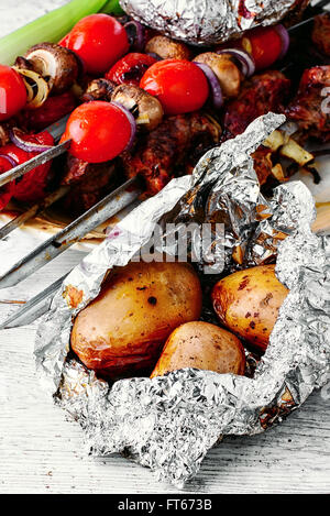 Gebackenes Rindfleisch und Kartoffeln in Folie auf die Kohlen Stockfoto