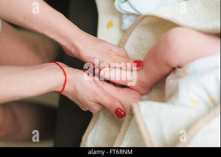 Mutter hält Füße des Neugeborenen Stockfoto