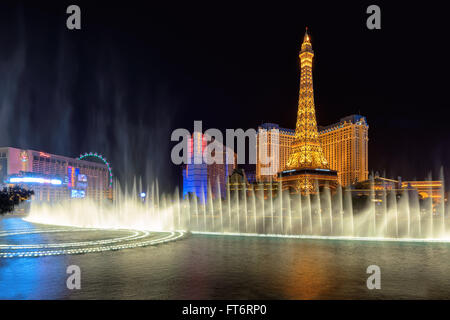 Das Bellagio tanzenden Fontänen in der Nacht und eine Nachbildung des Eiffelturms. Stockfoto