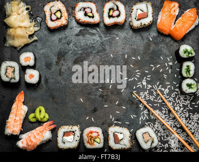 Sushi-Rollen, Maki, Nigiri, Lachs, Wasabi, Garnelen, Thunfisch, Tofu, Reis, Avocado, eingelegten Ingwer. Asiatische Küche-Hintergrund. Dunkel getönt Stockfoto