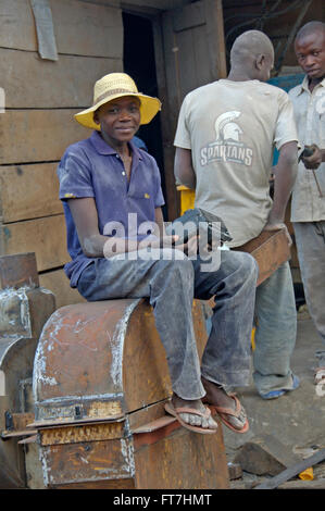 Kampala, Uganda-11 April 2017. Die Art und Weise Menschen leben in Uganda. Junge mit einer Pause von der Arbeit und hört Radio. Stockfoto