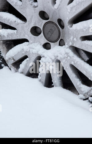 Ein Auto-Rad und Reifen sitzend in einer dicken Schicht Schnee bedeckt fast vollständig und nicht im Gebrauch wegen der Gefahr der Reisen in diesen Bedingungen. Stockfoto