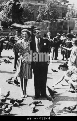 Junges Paar Fütterung Vögel in Trafalgar Square in London August 1947 Stockfoto