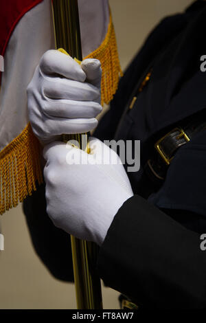 Die Hände eines Mitglieds der Zoll- und Rand-Schutz-Ehrengarde hält die amerikanische Flagge. Diese Bilder spiegeln die blaue Masse, die markiert den Beginn der nationalen Polizei-Woche in der Hauptstadt der Nation und Customs and Border Protection als Hommage an gefallenen Offiziere beteiligt. Der Erzbischof von Washington D.C., Kardinal Donald William Wuerl, leitet die Veranstaltung jährlich. Foto von James Tourtellotte. Stockfoto