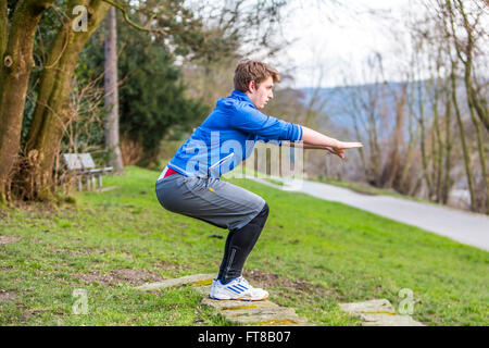 Junger Mann macht sich springen, outdoor-Sport, Fitness-Training, stand Stockfoto