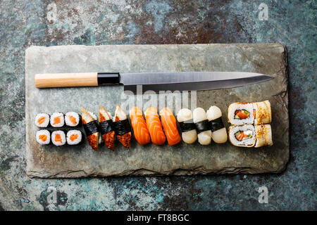 Sushi-Rollen und Nigiri mit japanischen Messer auf Stein Schiefer-Hintergrund Stockfoto