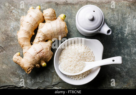 Roher Reis, frischer Ingwer und Sojasauce auf grauem Stein Schiefer-Hintergrund Stockfoto