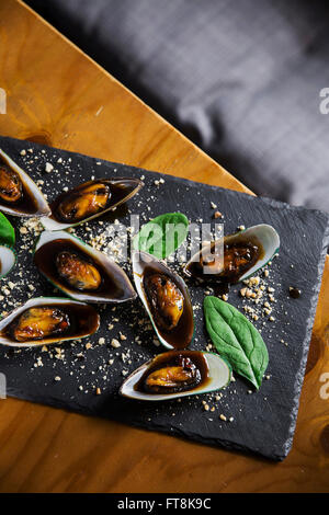 Asiatische Schale - Muscheln in klebrigen süßen Soße mit Erdnüssen und Spinat Stockfoto