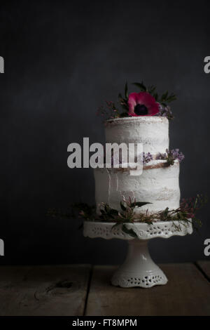 Hausgemachte Kuchen, Blume dekoriert, auf einem Ständer. Dunklen Hintergrund. Stockfoto