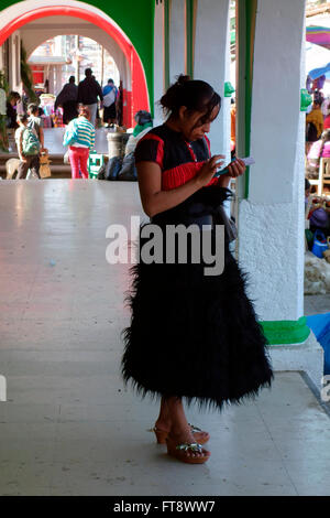 Chamula Mädchen mit ihrem Mobiltelefon auf dem Sonntagsmarkt in San Juan Chamula in der Nähe von San Cristobal de Las Casas, Chiapas, Mexiko Stockfoto