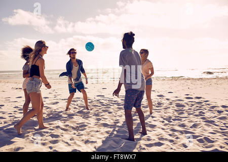 Porträt der Gruppe der happy Friends Spaß am Strand und an einem Sommertag mit Ball spielen. Stockfoto