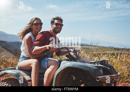 Porträt des jungen Liebespaar cruisen über Landstraßen von Quad-Fahrzeug. Glücklicher Mann und Frau ein Quad-Bike fahren. Stockfoto