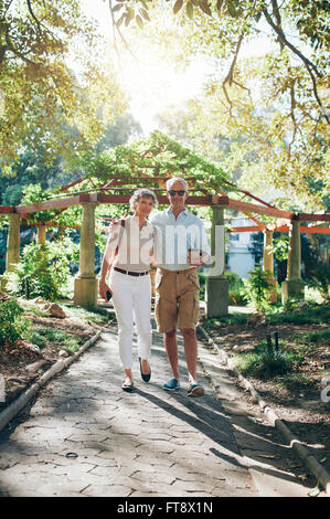 In voller Länge Portrait von senior Liebespaar zu Fuß durch einen Park. Ältere Touristen zu Fuß in einem Stadtpark. Stockfoto