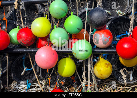 viele farbenfrohe Lobster Pot Angeln Angeln Marker Bojen hängen auf der die Kai warten auf Laden auf einem Fischerboot. Stockfoto