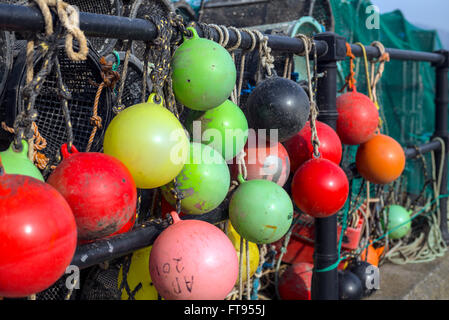 viele farbenfrohe Lobster Pot Angeln Angeln Marker Bojen hängen auf der die Kai warten auf Laden auf einem Fischerboot. Stockfoto