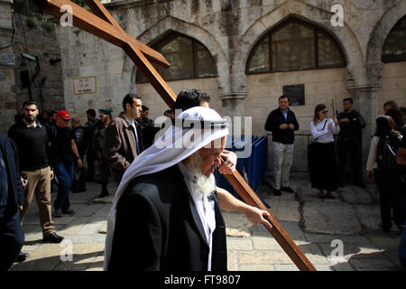 Jerusalem. 25. März 2016. Ein christlicher Pilger trägt ein hölzernes Kreuz entlang der Via Dolorosa (Weg des Leidens) in der Altstadt von Jerusalem während der Karfreitags-Prozession am 25. März 2016. © Muammar Awad/Xinhua/Alamy Live-Nachrichten Stockfoto