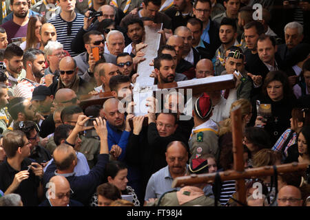 Jerusalem. 25. März 2016. Christliche Pilger tragen ein hölzernes Kreuz entlang der Via Dolorosa (Weg des Leidens) in der Altstadt von Jerusalem während der Karfreitags-Prozession am 25. März 2016. Bildnachweis: Muammar Awad/Xinhua/Alamy Live-Nachrichten Stockfoto