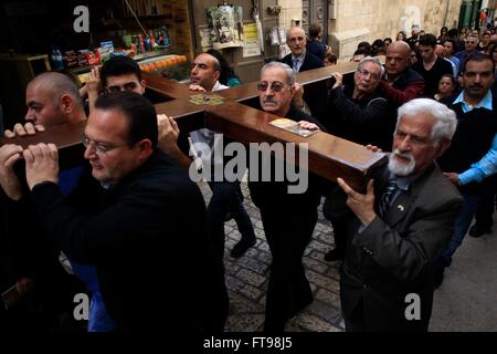 Jerusalem. 25. März 2016. Christliche Pilger tragen ein hölzernes Kreuz entlang der Via Dolorosa (Weg des Leidens) in der Altstadt von Jerusalem während der Karfreitags-Prozession am 25. März 2016. Bildnachweis: Muammar Awad/Xinhua/Alamy Live-Nachrichten Stockfoto