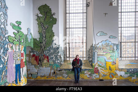 Bernburg, Deutschland. 23. März 2016. Maler und Grafiker Moritz Goetze aus Halle/Saale steht durch seine Bild-Reihe von biblischen Szenen auf Enamal Platten in der Schlosskirche St. Aegidien in Bernburg, Deutschland, 23. März 2016. Der Zyklus mit rund 320 Emaille Bilder entstanden in den letzten drei Jahren im Rahmen der Umstrukturierung der Barockkirche. Foto: Hendrik Schmidt/ZB/Dpa/Alamy Live News Stockfoto