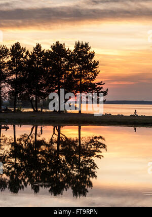 Gespiegelte Sonnenuntergang. Glasige stilles Wasser spiegelt die leuchtenden Orangen eines Sonnenuntergangs über dem Ottawa-Fluss und den Teich im park Stockfoto