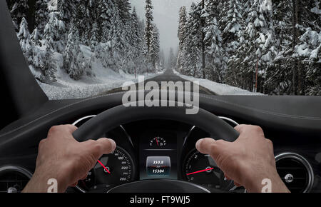 Autofahren in Schneewetter. Blick von der Fahrer-Winkel während Hände am Lenkrad. Stockfoto