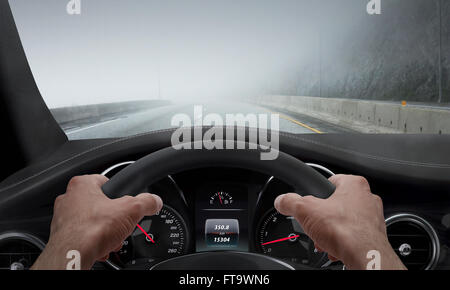 Fahren bei Nebel Wetter. Blick von der Fahrer-Winkel während Hände am Lenkrad. Stockfoto