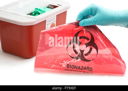 Health care Worker der Hand mit gefährlichem Abfall-Container und Tasche Handschuhen. Stockfoto