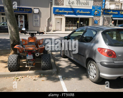 Eine orange Quad-Bike in der Nähe einer Boulangerie Patiserrie in Limoux Frankreich geparkt Stockfoto