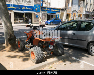 Eine orange Quad-Bike in der Nähe einer Boulangerie Patiserrie in Limoux Frankreich geparkt Stockfoto