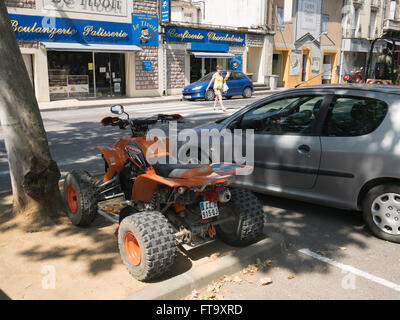 Eine orange Quad-Bike in der Nähe einer Boulangerie Patiserrie in Limoux Frankreich geparkt Stockfoto