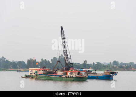 Baggerarbeiten Schiff umgeben von Lastkähnen, die Gewinnung von Kies und Sand aus dem Flussbett des Mekong-Fluss-Delta in Vietnam. Stockfoto