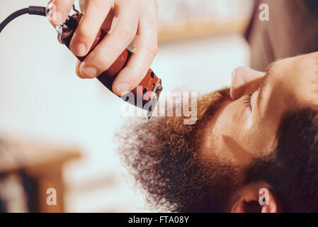 Professionelle Friseur schneiden Bart von angenehmer Mensch Stockfoto