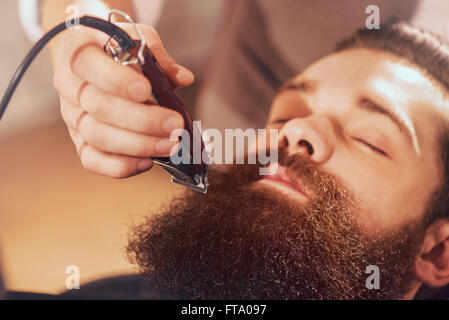 Professionelle Friseur schneiden Bart von angenehmer Mensch Stockfoto