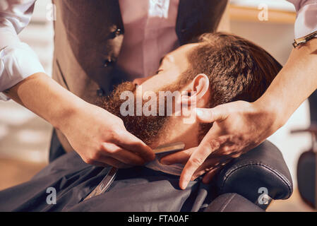 Professionellen Barbier rasieren Bart des Auftraggebers Stockfoto