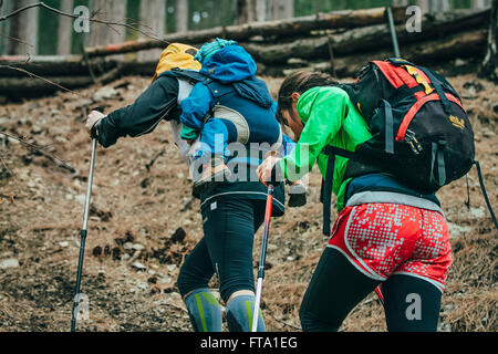 Papa und Mama und ihr Kind zu Fuß auf einem Waldweg in Mount während Bergmarathon Stockfoto