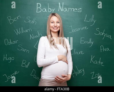 Schwangere Frau versucht, einen Namen für ihr Baby wählen Stockfoto