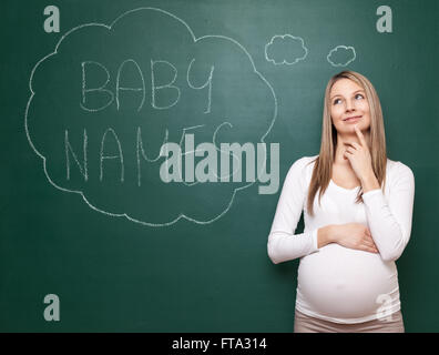 Schwangere Frau versucht, einen Namen für ihr Baby wählen Stockfoto