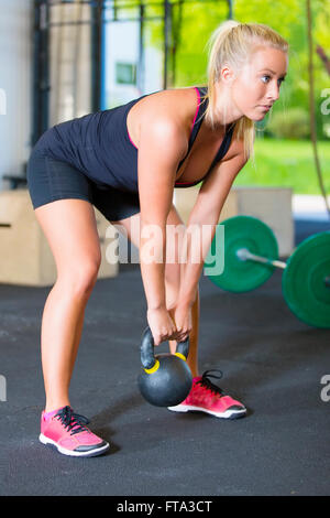 Frauen trainieren mit Kettlebell im Fitness-Studio Stockfoto