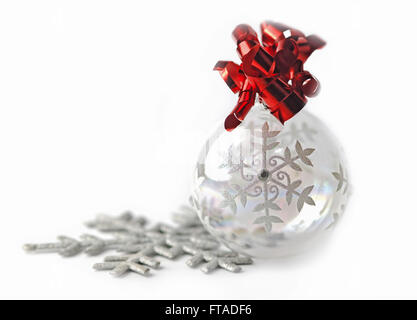 Transparente Weihnachtskugel mit rotem Band isoliert auf weißem Hintergrund Stockfoto