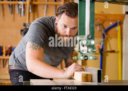 Handwerker mit Band sah zum Spalten von Holz Balken im workshop Stockfoto