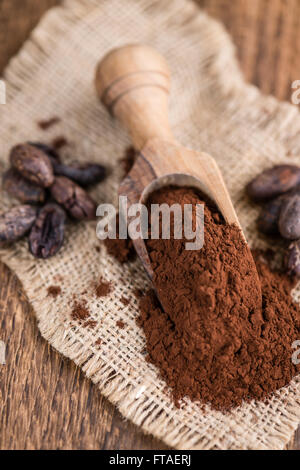 Natürlichen Kakao-Pulver (detaillierte Nahaufnahme) auf einem alten Holztisch (Tiefenschärfe) Stockfoto