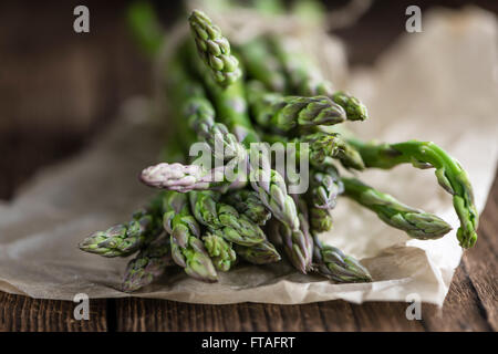 Portion grüner Spargel (Nahaufnahme) auf hölzernen Hintergrund Stockfoto