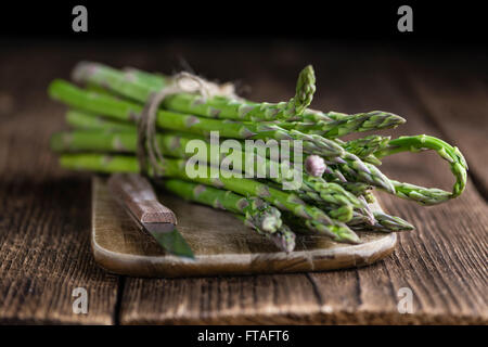 Frischer grüner Spargel (Tiefenschärfe, Nahaufnahme) auf hölzernen Hintergrund Stockfoto