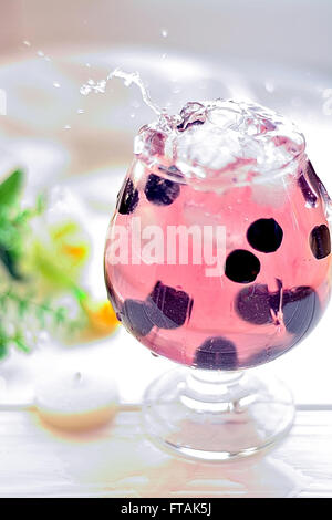 Cocktail in ein Glas mit Beeren und Wasser spritzt Stockfoto