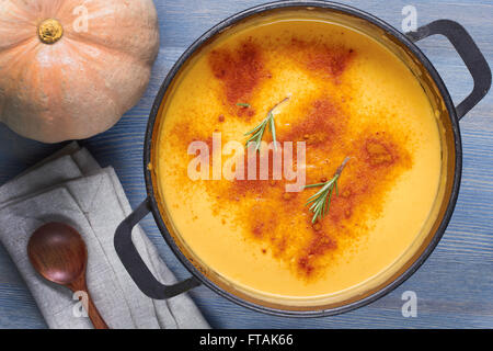 Kürbissuppe im Topf auf Holztisch Stockfoto