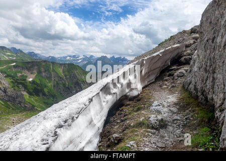 Wanderweg in den Allgäu Alpen im Sommer zwischen Felsen und ein letztes Schneefeld. In der Nähe von Oberstdorf, Deutschland übernommen. Stockfoto
